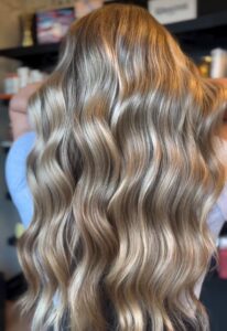 Golden, dimensional blonde balayage with warm tones styled in long waves by Annie Miller, Franklin, TN hairstylist