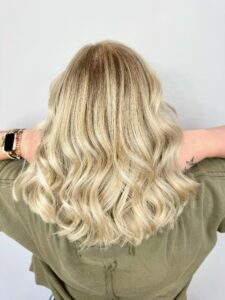 Bright all-over blonde with a soft dark root shadow styled in loose curls by Gabby Allen, Lebanon, TN hairstylist